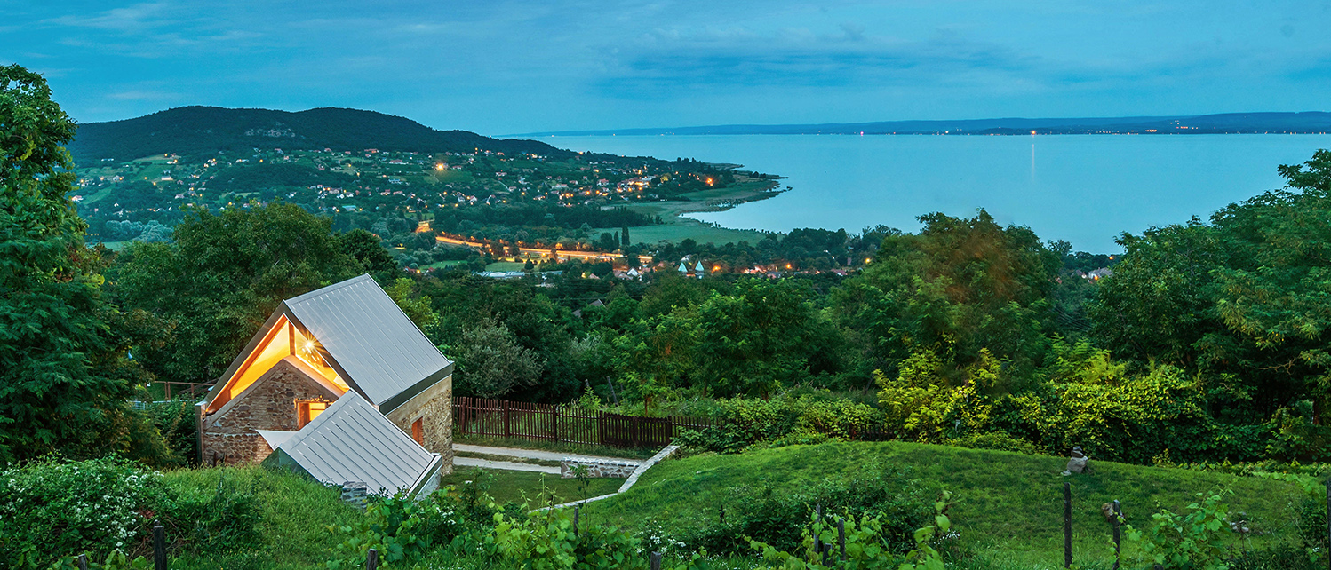 118-badacsony-kohaz-ga-v Kőház a hegyen nevű felújított egykori présház, mint modern nyaraló a Badacsony oldalában, kékórában, kilátással a Balatonra